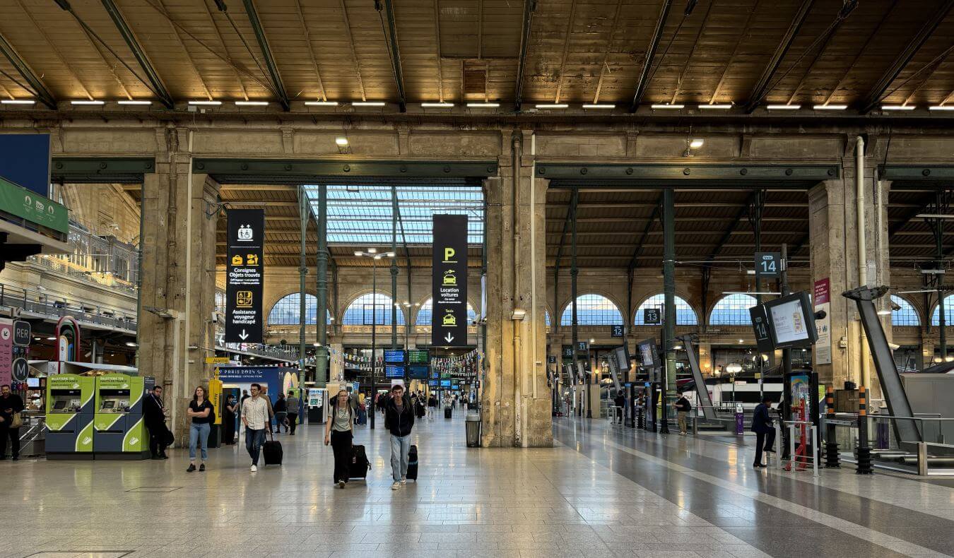 People walking around a train station in France