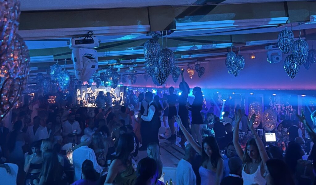 A club in Spain with people dancing under neon lights